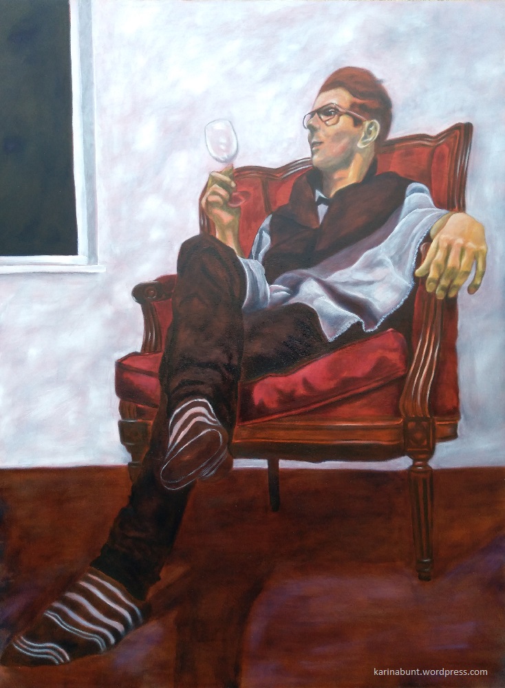 Junger Mann im Lehnsessel sitzend, ein leeres Weinglas in der Hand